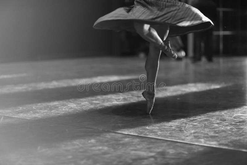 Legs of ballerina dancing in pointe at rehearsal in the hall