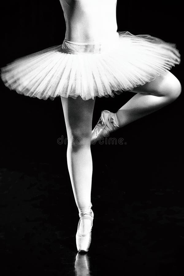 Legs of ballerina, Pointe shoes. ballet dancers on the dark black background close up shoot. Legs of ballerina, Pointe shoes. ballet dancers on the dark black background close up shoot