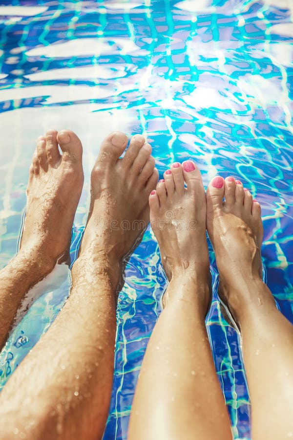 Legs of a couple in love in the swimming pool men and women - summer travel concept. Legs of a couple in love in the swimming pool men and women - summer travel concept