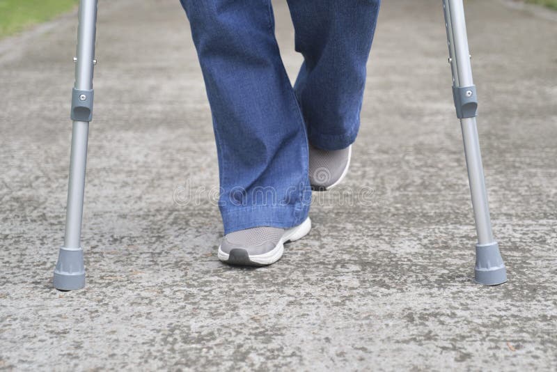 Legs and Feet of an Unrecognizable Person Walking with the Help of Crutches Stock Image Image