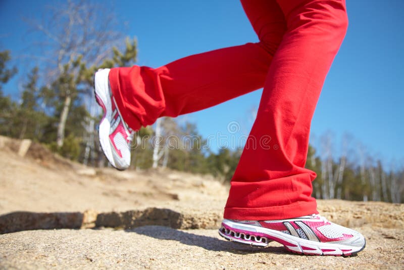 Close-up legs of a girl jogging on the wood. Close-up legs of a girl jogging on the wood