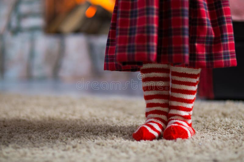 legs of a little girl in red white striped socks celebrating Christmas at home