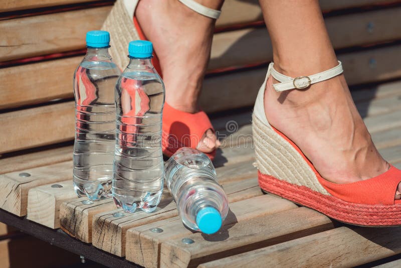 Legs of a Young girl with a bottles of water. healthy lifestyle concept. girl suffering summer heat. Legs of a Young girl with a bottles of water. healthy lifestyle concept. girl suffering summer heat.