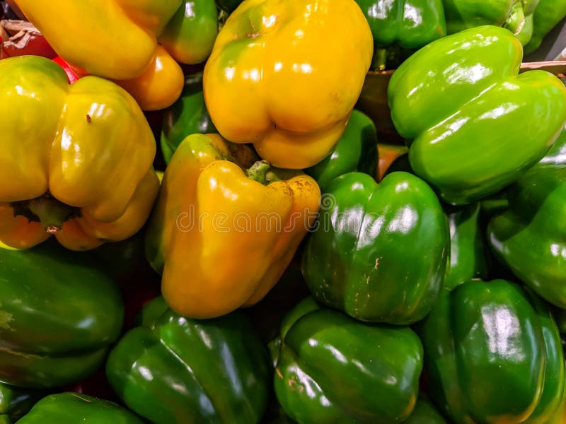 Legumes de pimenta amarelos e verdes, deliciosos, saudáveis e frescos, empilhados numa pilha numa loja num supermercado para vend foto de stock royalty free