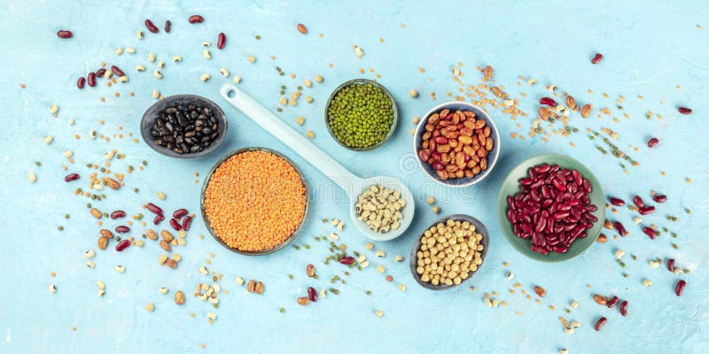 Legumes, overhead panoramic shot on a blue background. Vibrant pulses including colourful beans, lentils, soybeans, chickpeas, a flatlay. Legumes, overhead panoramic shot on a blue background. Vibrant pulses including colourful beans, lentils, soybeans, chickpeas, a flatlay