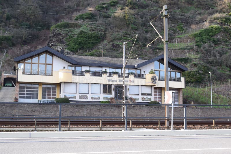 Mosel valley road near Lehmen with the railroad and a winery next to the steep vineyards terraces on the north side of the river. Mosel valley road near Lehmen with the railroad and a winery next to the steep vineyards terraces on the north side of the river