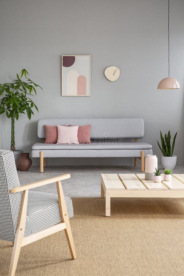 Lehnsessel und Holztisch im grauen Wohnzimmerinnenraum mit Beitrag lizenzfreies stockfoto Lehnsessel und Holztisch im grauen Wohnzimmerinnenraum mit Beitrag lizenzfreies stockfoto