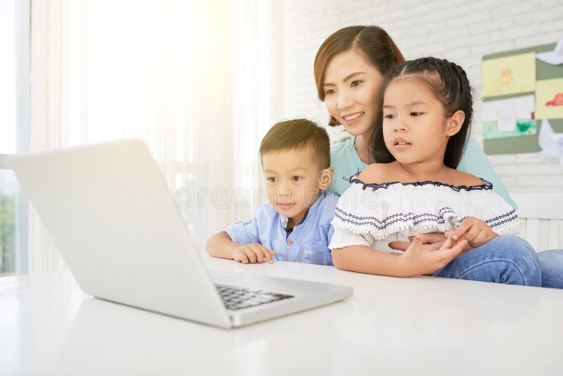 Lehrer und Kinder, die Laptop aufpassen stockfotografie Lehrer und Kinder, die Laptop aufpassen stockfotografie