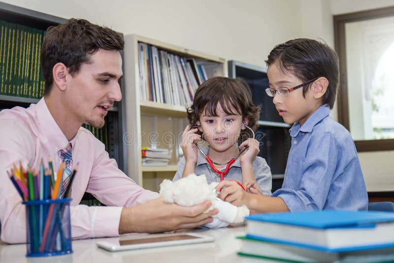 Lehrer und Studenten spielen Doktor mit Stethoskop stockfoto Lehrer und Studenten spielen Doktor mit Stethoskop stockfoto