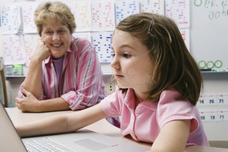 Lehrer-Watching Schoolgirl Use-Laptop lizenzfreie stockbilder Lehrer-Watching Schoolgirl Use-Laptop lizenzfreie stockbilder