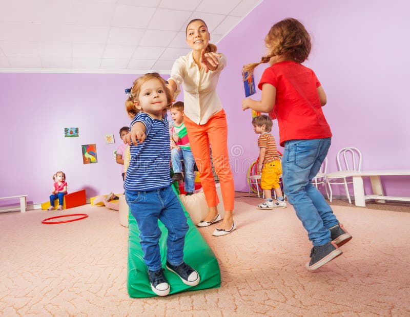 Lehrer zeigt die laufenden und springenden Kinder auf Zuschauer lizenzfreies stockfoto Lehrer zeigt die laufenden und springenden Kinder auf Zuschauer lizenzfreies stockfoto