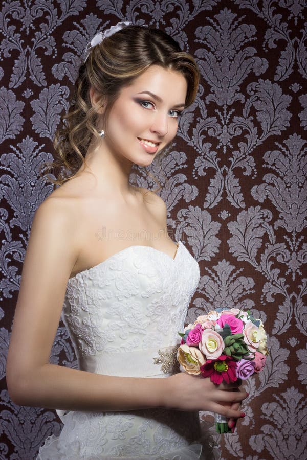 Leichtes Porträt von glücklichen lächelnden schönen sexy Mädchen im weißen Hochzeitskleid mit einem Hochzeitsblumenstrauß in der stockfotos Leichtes Porträt von glücklichen lächelnden schönen sexy Mädchen im weißen Hochzeitskleid mit einem Hochzeitsblumenstrauß in der stockfotos