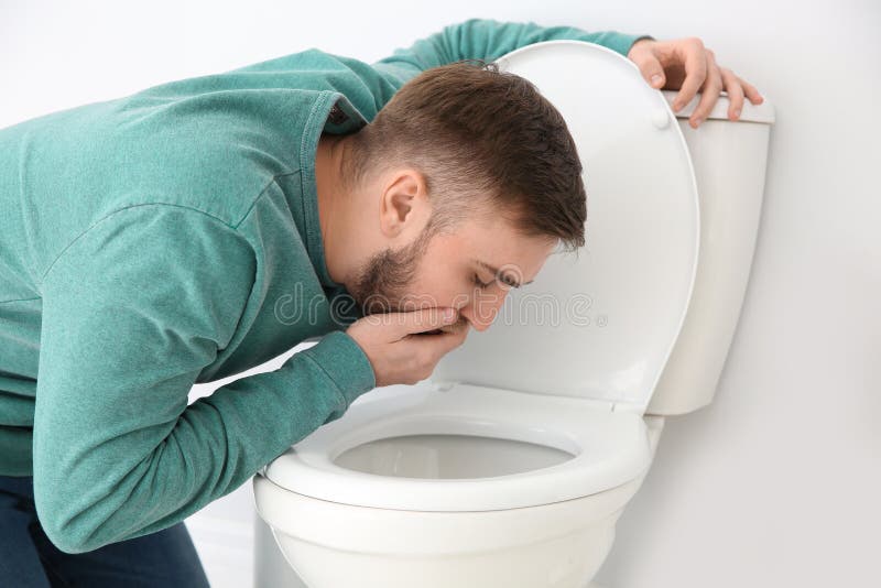 Leiden des jungen Mannes von der Übelkeit über Toilettenschüssel lizenzfreies stockfoto Leiden des jungen Mannes von der Übelkeit über Toilettenschüssel lizenzfreies stockfoto