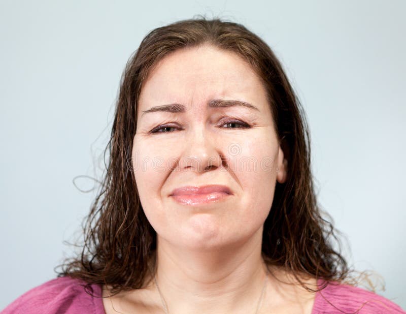 Leiden und Schmerzen auf dem Gesicht einer erwachsenen Frau, Portrait auf grauem Hintergrund, Emotionen Serie lizenzfreie stockfotografie