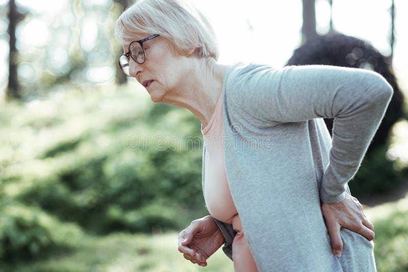 Leidende Rückseite der Schmerz der älteren Frau herein stockfoto Leidende Rückseite der Schmerz der älteren Frau herein stockfoto