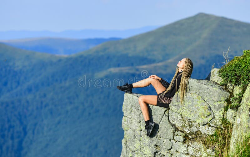 Leiderschapsconcept. rotsklimvaardigheid. het bereiken van de top. vrouw ontspant zich in bergafeltje. voel vrijheid. uiterst vrij