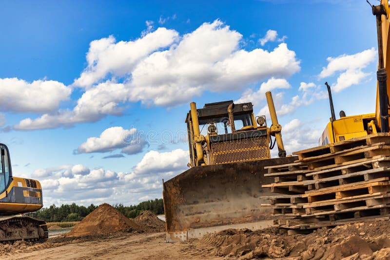 Powerful construction equipment for the construction of a new facility. Construction equipment for earthworks. Modern building site. Excavators, bulldozers, loaders, graders. Powerful construction equipment for the construction of a new facility. Construction equipment for earthworks. Modern building site. Excavators, bulldozers, loaders, graders.