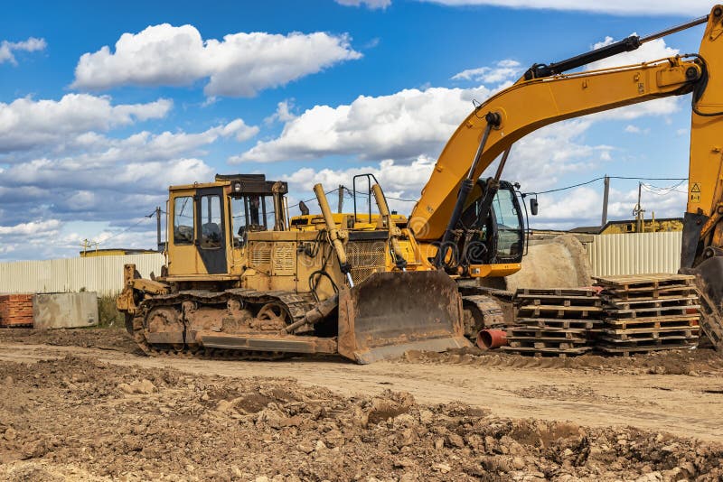 Powerful construction equipment for the construction of a new facility. Construction equipment for earthworks. Modern building site. Excavators, bulldozers, loaders, graders. Powerful construction equipment for the construction of a new facility. Construction equipment for earthworks. Modern building site. Excavators, bulldozers, loaders, graders.