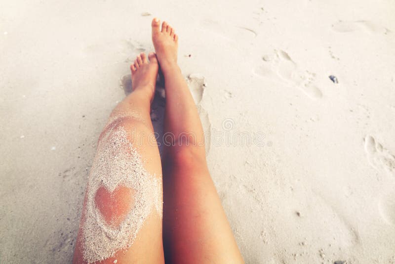 Leisure in summer - Beautiful women tan. relax on beach with sand of heart shape stock image Leisure in summer - Beautiful women tan. relax on beach with sand of heart shape stock image