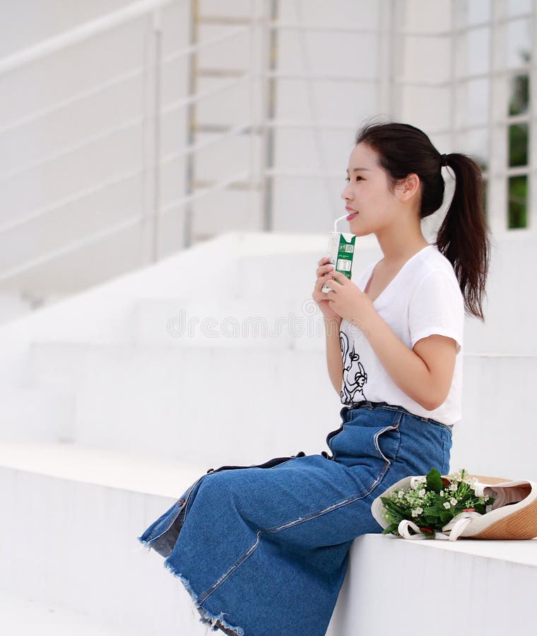 Leite chinês asiático da bebida da estudante universitário no campo de jogos foto de stock Leite chinês asiático da bebida da estudante universitário no campo de jogos foto de stock