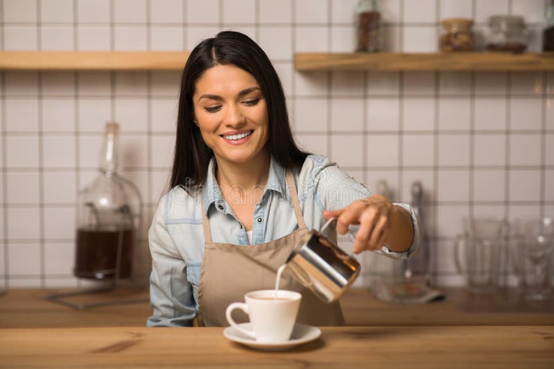 Leite de derramamento de Barista no café imagem de stock Leite de derramamento de Barista no café imagem de stock