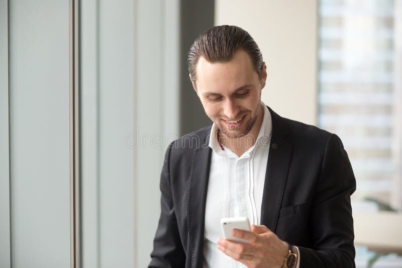 Leitura do homem de negócios e mensagens da emissão no telefone imagens de stock Leitura do homem de negócios e mensagens da emissão no telefone imagens de stock