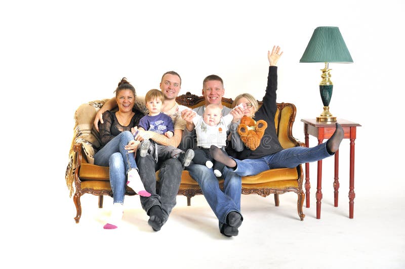 Lek för två ung familjer som dumbommen med ett barn sitter på en soffa royaltyfria foton Lek för två ung familjer som dumbommen med ett barn sitter på en soffa royaltyfria foton