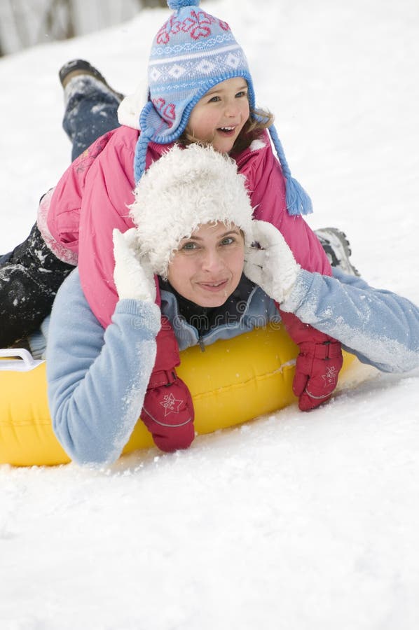 Mother and daughter sliding on snow. Mother and daughter sliding on snow
