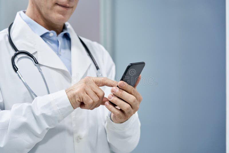 Lekarz mężczyzna korzystający z mobilnej poczty elektronicznej.
