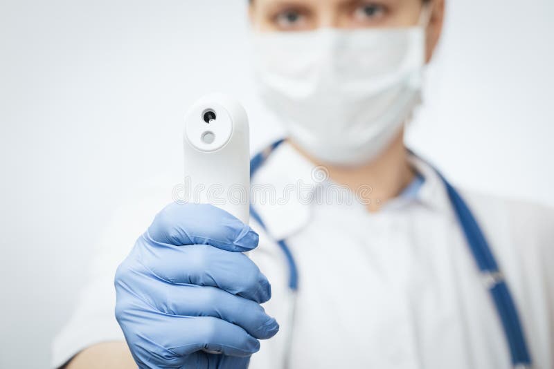 Lekarze wskazujący pistolet termometru podczerwieni na sprawdzenie koncepcji epidemii wirusa temperatury ciała