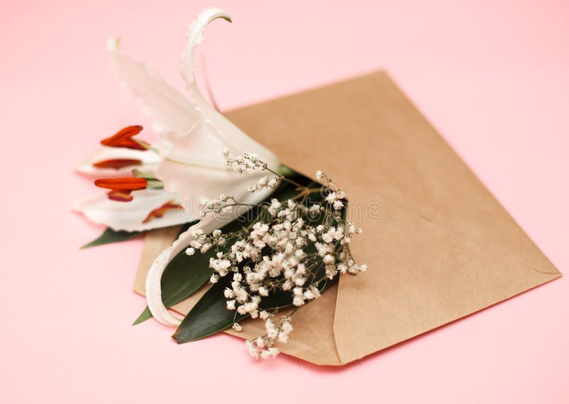Lekmanna- sammansättning för dekorativ lägenhet med det kraft kuvertet och blommor Lekmanna- lägenhet, bästa sikt på rosa färger royaltyfri fotografi Lekmanna- sammansättning för dekorativ lägenhet med det kraft kuvertet och blommor Lekmanna- lägenhet, bästa sikt på rosa färger royaltyfri fotografi