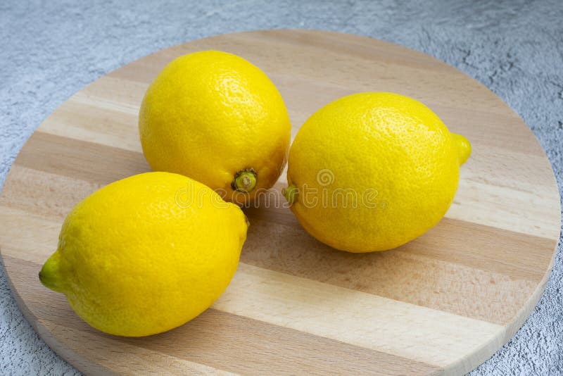 Lemon on a Light Wood Chopping Board and on a Gray Table. Citrus Fruit