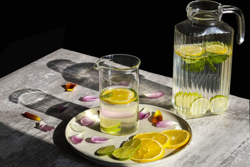 Citrus and Mint Lemonade in a Jug and a Jar Standing on the Table with