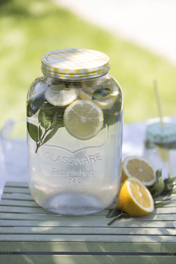Lemonade in the Jug and Lemons with Mint on the Table Outdoor Stock