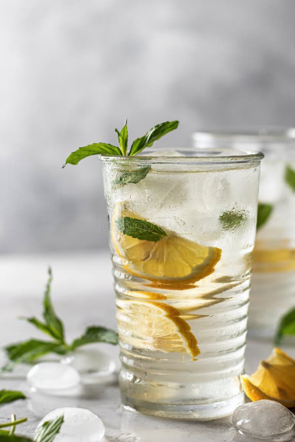 Lemonade or mojito cocktail with lemon and mint, summer iced refreshing drink on gray background royalty free stock photography