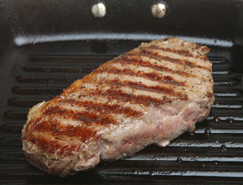 Lendenstück-Steak in der Bratpfanne-Wanne stockbild Lendenstück-Steak in der Bratpfanne-Wanne stockbild