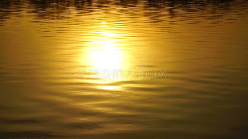 Lengte mooie zonsondergang die in water wordt weerspiegeld