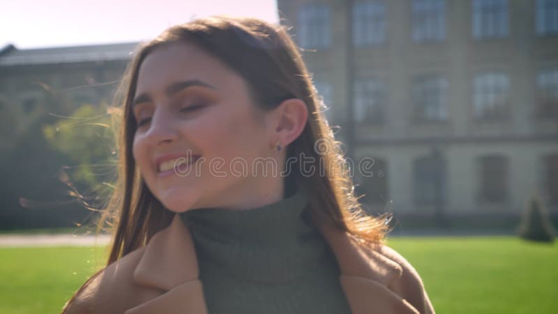 Lengte, profiel van lopende mooie Kaukasische vrouw met lang donker haar en gelukkige glimlach, die vooruit recht kijken