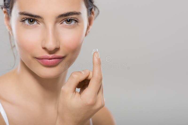 Lente a contatto d'uso della donna fotografia stock libera da diritti Lente a contatto d'uso della donna fotografia stock libera da diritti