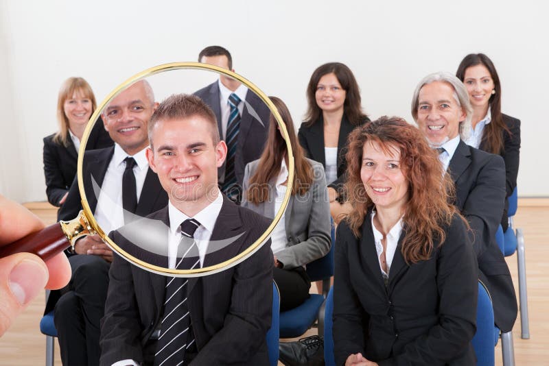 Lente d'ingrandimento che seleziona il migliore candidato per il lavoro fotografia stock Lente d'ingrandimento che seleziona il migliore candidato per il lavoro fotografia stock