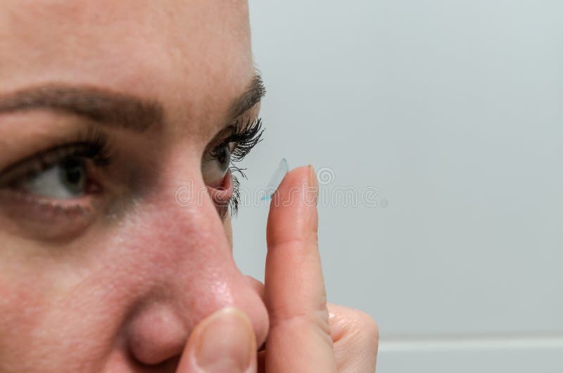 Lentes de contacto de la mujer que llevan para la corrección de la visión imágenes de archivo libres de regalías Lentes de contacto de la mujer que llevan para la corrección de la visión imágenes de archivo libres de regalías