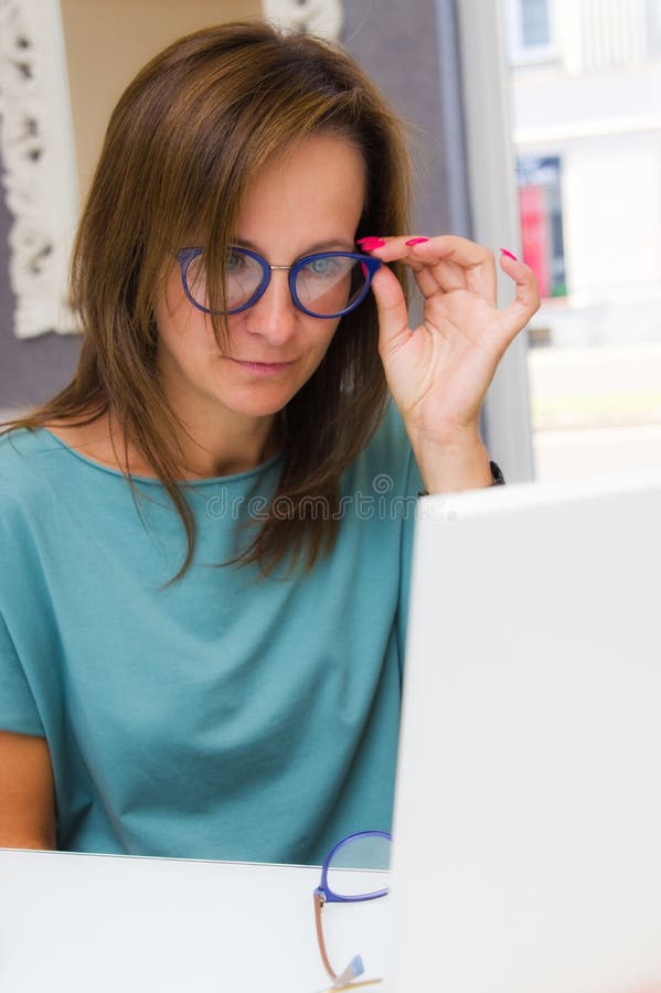Lentes que eligen y de compras de la mujer morena en salón o tienda del óptico fotos de archivo libres de regalías Lentes que eligen y de compras de la mujer morena en salón o tienda del óptico fotos de archivo libres de regalías