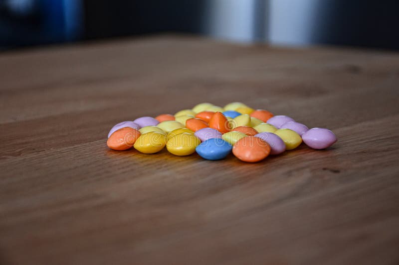 Lenticchie colorate con cioccolato sul tavolo fotografie stock