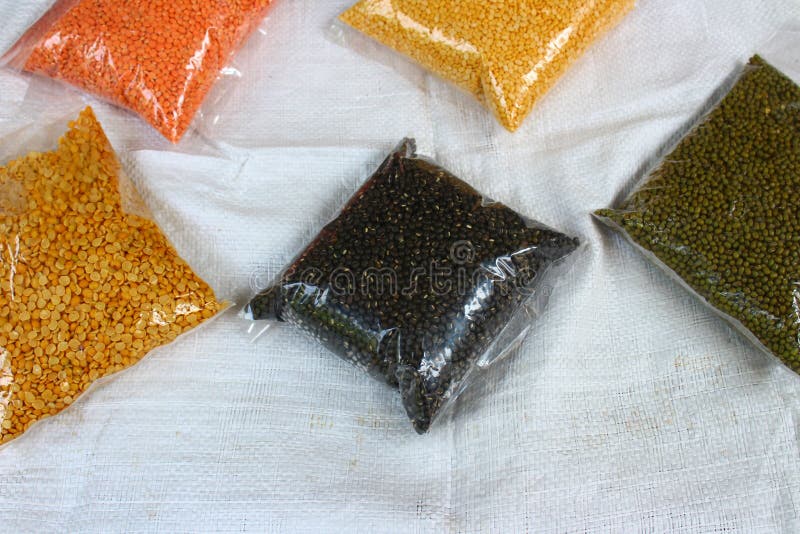Lenticchie colorate in confezioni di plastica fotografia stock