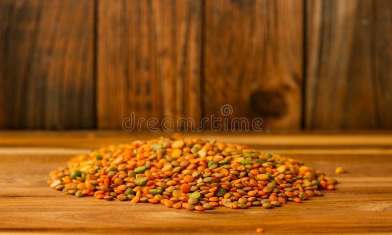Lenticchie su una tavola di legno con fondo di legno fotografie stock