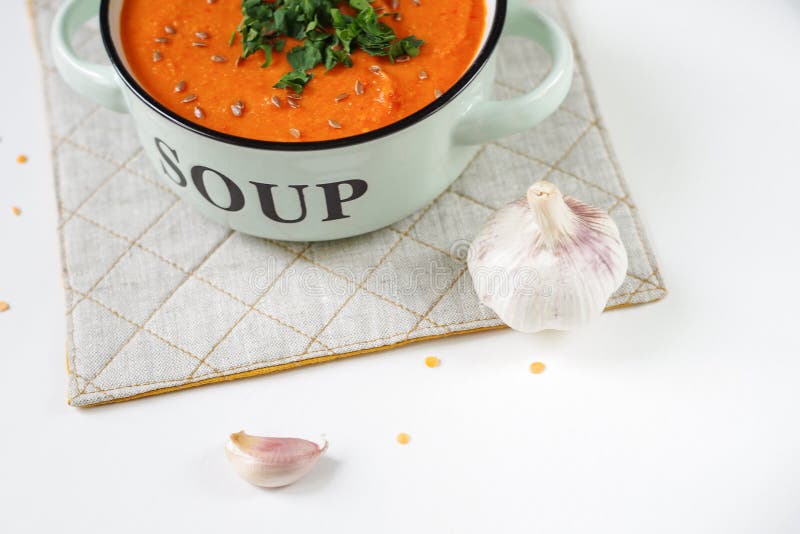 Lentil Tomato Cream Soup in a Rustic Bowl with Garlic. Stock Photo