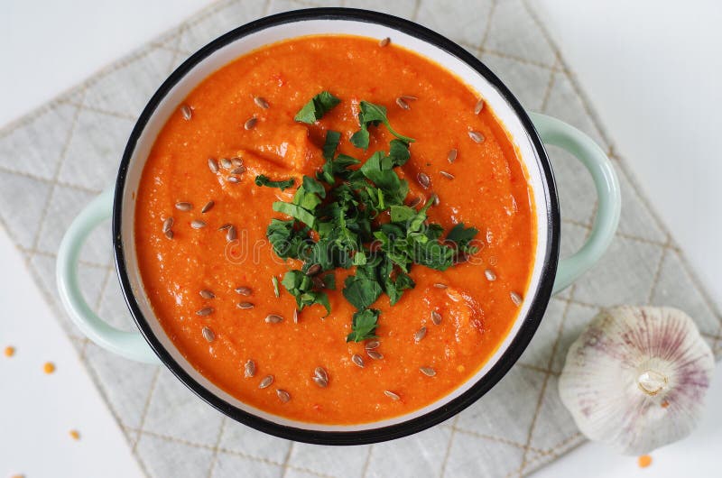 Lentil Tomato Cream Soup in a Rustic Bowl with Garlic. Stock Photo