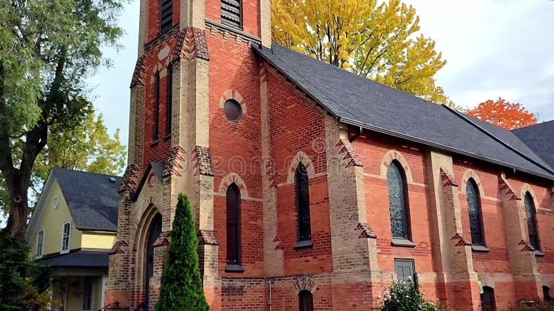 Lento movimento delle telecamere all'esterno di una chiesa e il colore della foglia autunnale di una piccola città