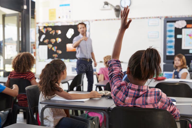 Leraar die aan basisschoolstudent richten in klasse stock afbeelding Leraar die aan basisschoolstudent richten in klasse stock afbeelding