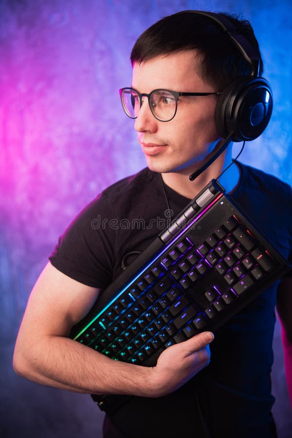 Lerdo do computador com o teclado sobre o rosa colorido e a parede leve de néon azul fotos de stock Lerdo do computador com o teclado sobre o rosa colorido e a parede leve de néon azul fotos de stock
